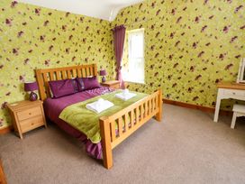 A bedroom with a wooden bed and nightstands at The Sycamores in Llawhaden near Narberth