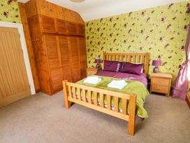 A bedroom with a bed and wardrobe at The Sycamores Llawhaden near Narberth
