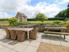 An outdoor area with a table and chairs at The Sycamores in Llawhaden near Narberth