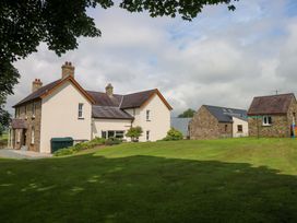 A house and garage with green grass and trees at The Sycamores in Llawhaden near Narberth