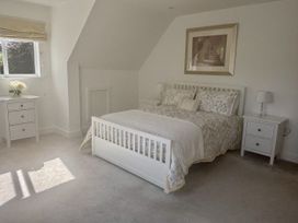 A bedroom with a bed and nightstands at 8 Church Road in Ferndown