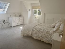 A bedroom with bed and dresser at 8 Church Road Ferndown