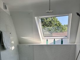 A bathroom with a shower area and window at 8 Church Road Ferndown