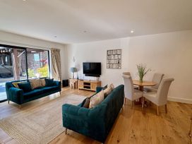 A living room with a sofa and dining area at 8 Church Road in Ferndown