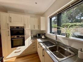 A kitchen with sink and windows at 8 Church Road in Ferndown