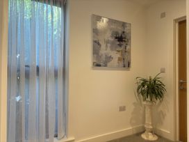 A corner with a curtain, painting, plant and door at 8 Church Road in Ferndown