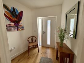 A hallway with a chair, table, and mirror at 8 Church Road Ferndown