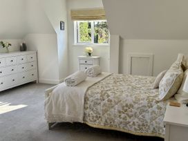 A bedroom with a bed and dresser at 8 Church Road in Ferndown