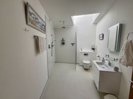 A bathroom with a shower, toilet, and sink at 8 Church Road Ferndown