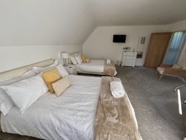 A bedroom with two beds and a TV at 8 Church Road in Ferndown