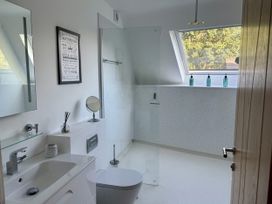 A bathroom with a sink, toilet, and shower at 8 Church Road in Ferndown