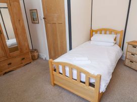 A bedroom with a single bed and wardrobe at Pelican Cottage St Ives