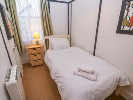 A bedroom with a single bed and a nightstand at Pelican Cottage St Ives