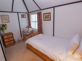 A bedroom with a single bed and a chair at Pelican Cottage in St Ives
