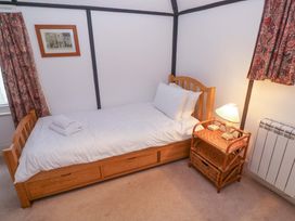 A bedroom with a single bed and lamp at Pelican Cottage in St Ives