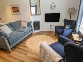 A living room with a sofa and television at Pelican Cottage St Ives