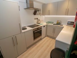 A kitchen with modern appliances and storage at Pelican Cottage in St Ives