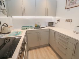 A kitchen with a sink and microwave at Pelican Cottage in St Ives