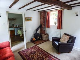 A living room with a stove and sofa at The Smithy Lucton near Mortimers Cross
