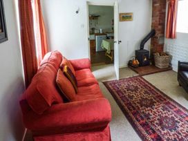 A living room with a sofa and fireplace at The Smithy in Lucton near Mortimers Cross