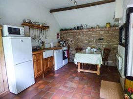 A kitchen with appliances and a dining table at The Smithy in Lucton near Mortimers Cross
