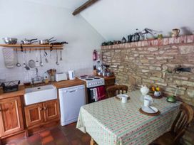 A kitchen with a sink, stove, and table at The Smithy in Lucton near Mortimers Cross