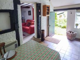 A kitchen with a table and chair leading to an entry door at The Smithy in Lucton near Mortimers Cross