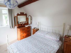 A bedroom with a bed and dresser at The Smithy in Lucton near Mortimers Cross