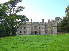 A castle with a lawn and trees at The Smithy in Lucton near Mortimers Cross