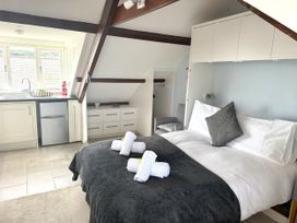A bedroom with a bed and kitchenette at Crows Nest in St Ives