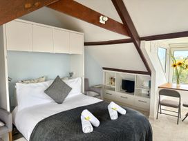 A bedroom with a bed and a small table at Crows Nest St Ives