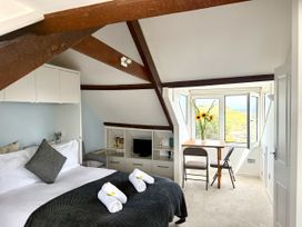A bedroom with a bed and table at Crows Nest in St Ives