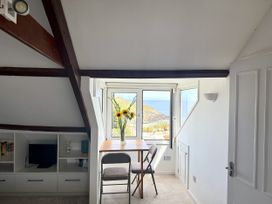 A room with a table and chair overlooking the sea at Crows Nest in St Ives