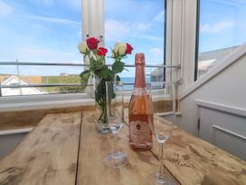 A dining area with a bottle of prosecco and glasses at Seagulls Nest in St Ives