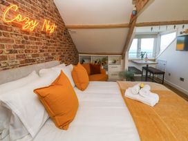 A bedroom with a bed and sofa at Seagulls Nest in St Ives