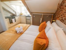 A bedroom with a kitchen area and bed at Seagulls Nest in St Ives