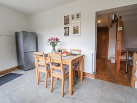 A kitchen with a dining table and chairs at The Hayloft in Bodelwyddan