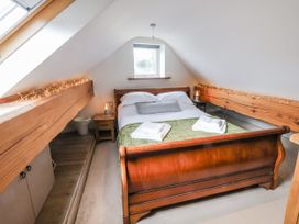 A bedroom with a bed and wooden beams at The Hayloft in Bodelwyddan