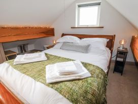 A bedroom with a bed and bedside table at The Hayloft in Bodelwyddan