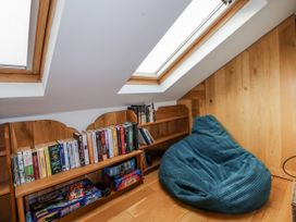 A reading nook with bookshelves and a bean bag at The Hayloft in Bodelwyddan