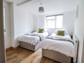 A bedroom with two single beds and a window at The Hayloft in Bodelwyddan