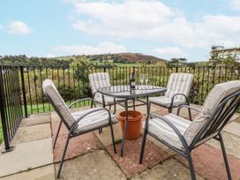 An outdoor patio with a table and chairs at The Hayloft in Bodelwyddan