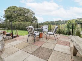 A patio with a table and chairs at The Hayloft in Bodelwyddan