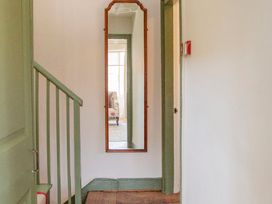A hallway with a mirror and staircase at Apartment 2, 86 Dyer Street Cirencester