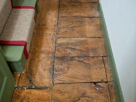 A wooden floor with an armchair in a hallway at Apartment 2, 86 Dyer Street Cirencester