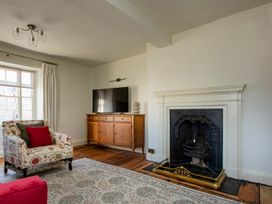 A living room with a fireplace and television at Apartment 2, 86 Dyer Street Cirencester