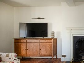 A living room with a television and wooden sideboard at Apartment 2, 86 Dyer Street Cirencester