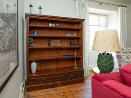 A bookcase with books and decorative items in a living room at Apartment 2, 86 Dyer Street in Cirencester
