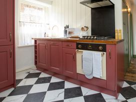 A kitchen with a stove and cabinets at Apartment 2, 86 Dyer Street Cirencester
