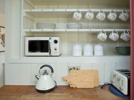 A kitchen with a microwave kettle and toaster at Apartment 2, 86 Dyer Street Cirencester